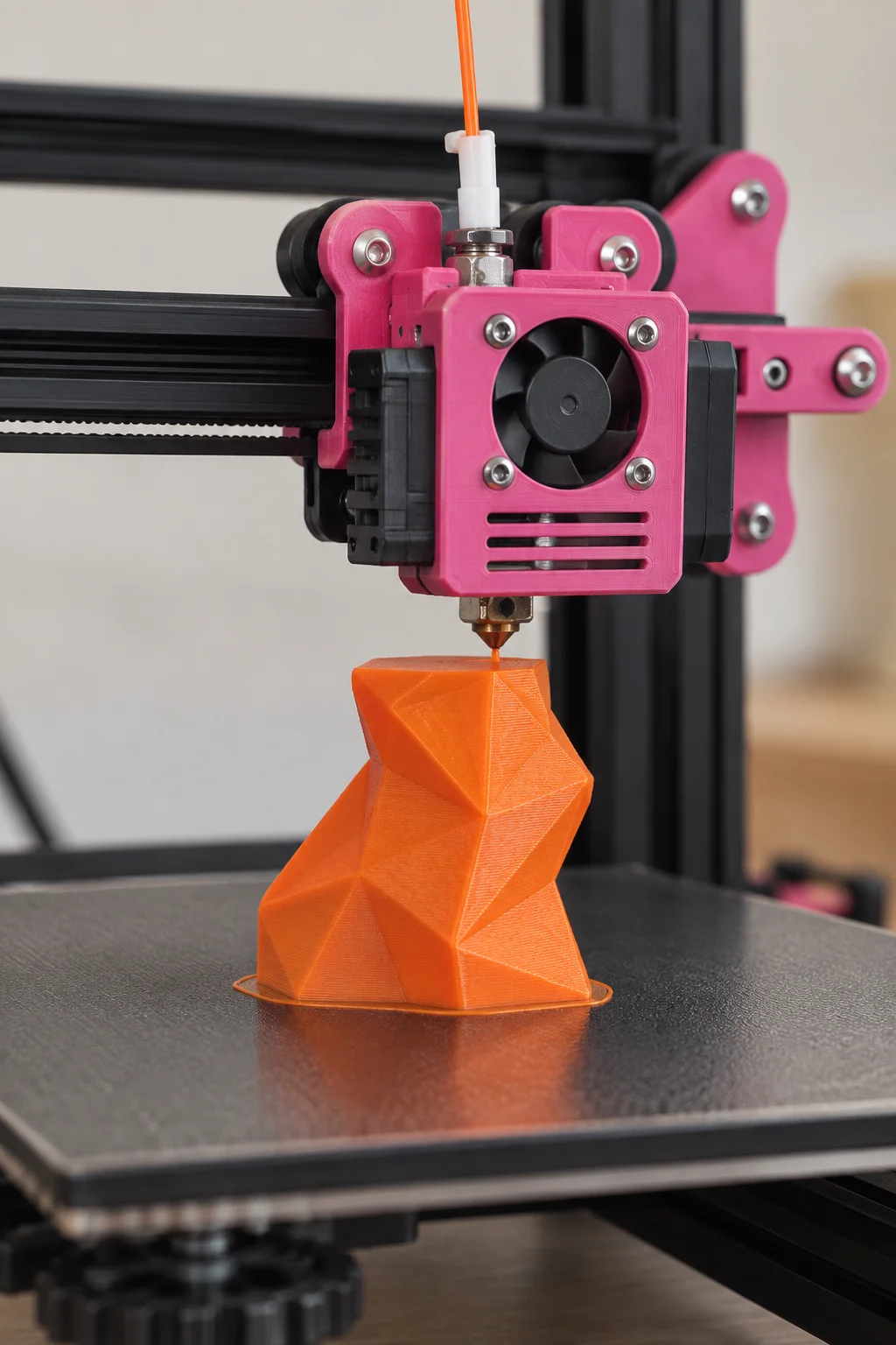 Detalhe da impressora 3D produzindo uma peça laranja